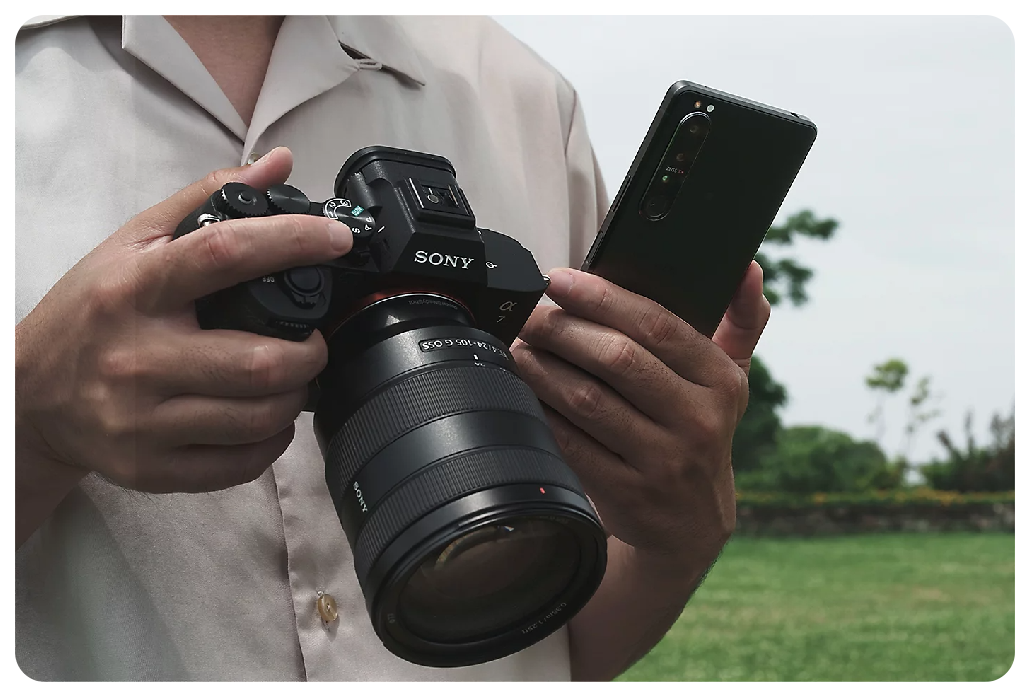 Photographer holding Sony A7 IV Camera and smartphone